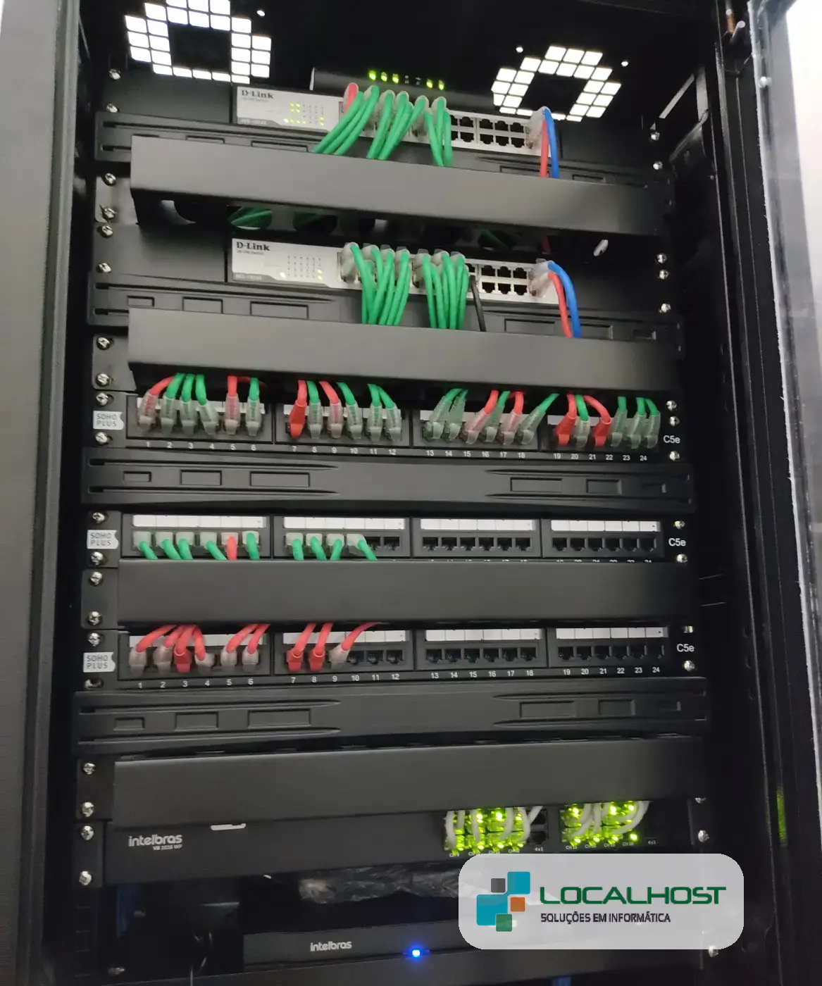 Rack de rede organizado com switches e patch panels, instalado pela Localhost